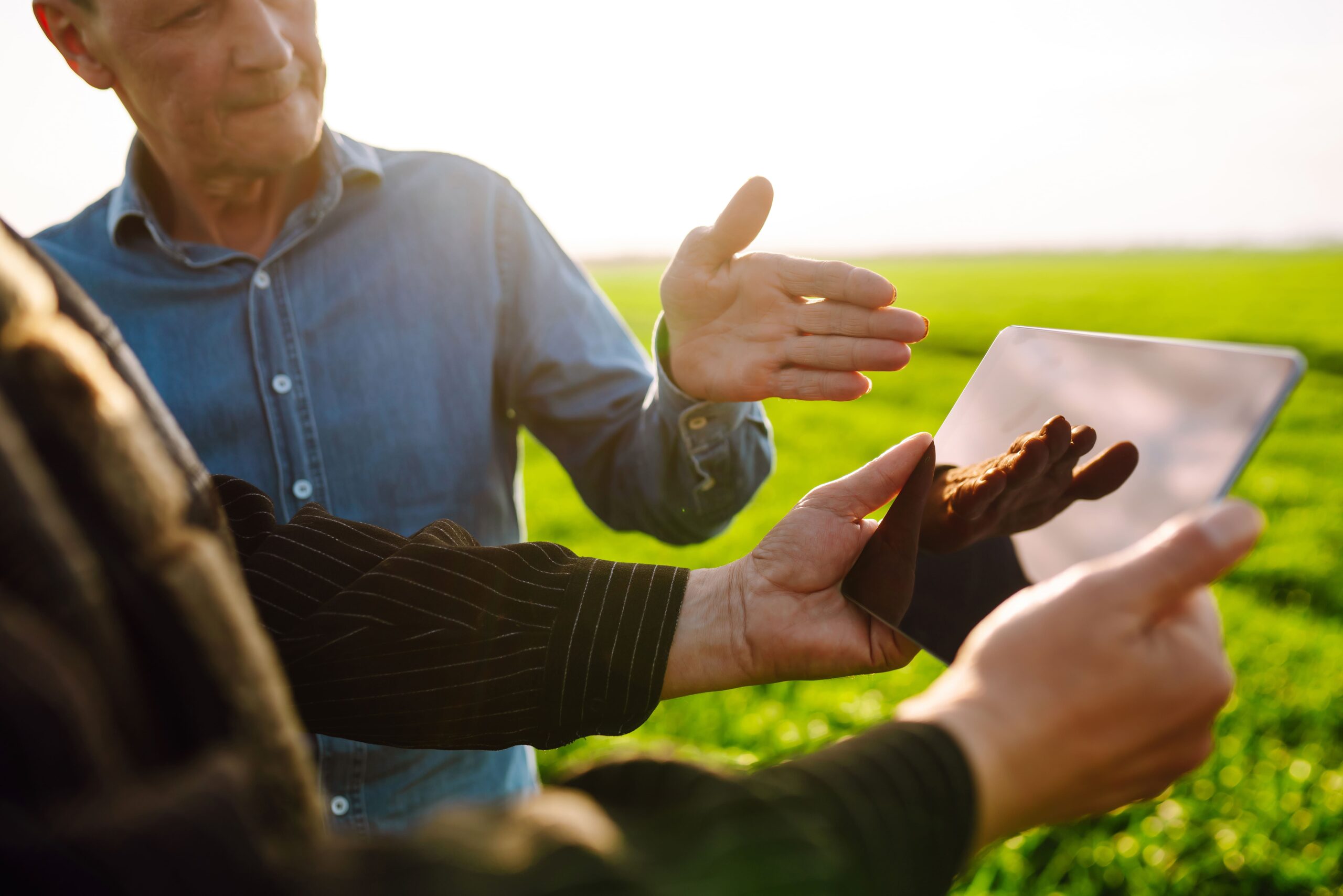 Consultor de campo entregando/mostrando uma proposta em tablet para o produtor rural
